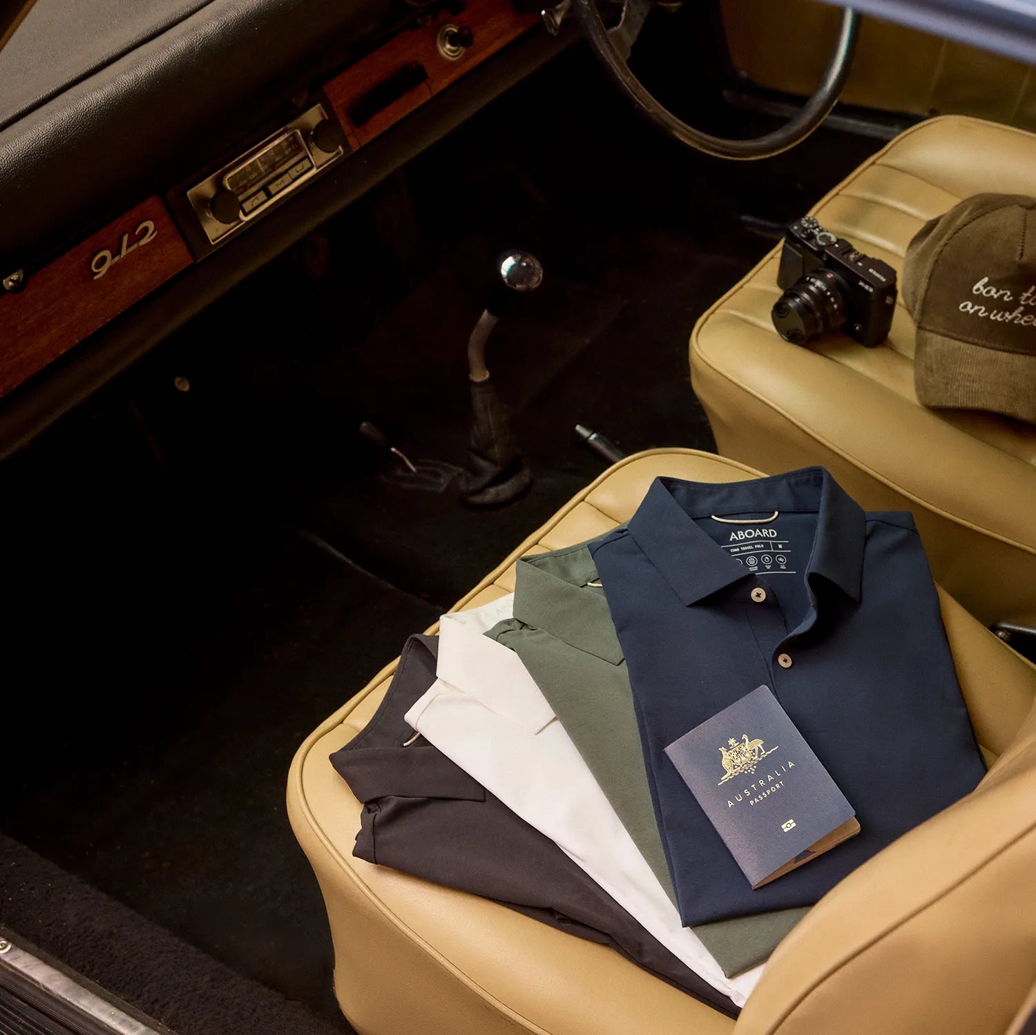 ABOARD Como Travel Polo collection in Black, Navy, White, and Sea Green, displayed on Porsche seat, engineered for style and performance.