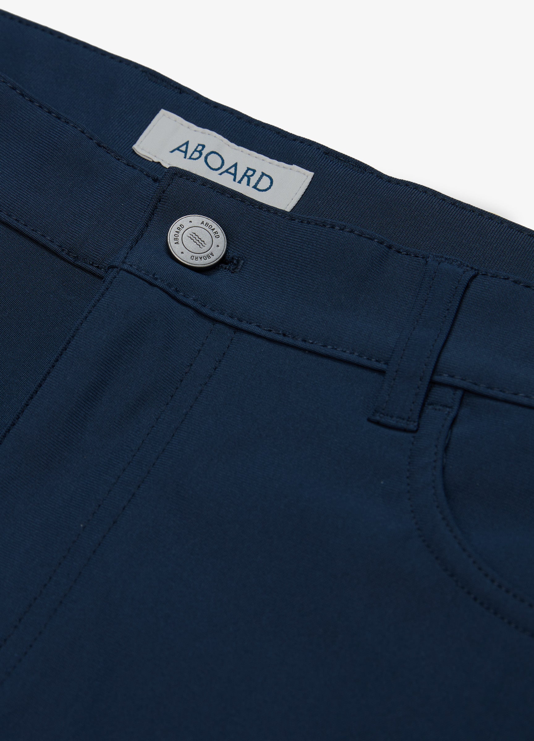 Four Seasons Travel Pant in Navy – Close-Up of Logo Metal Button & Premium Fabric #color_navy