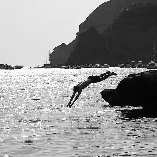 Man diving into ocean. ABOARD Apparel. Designed to travel
