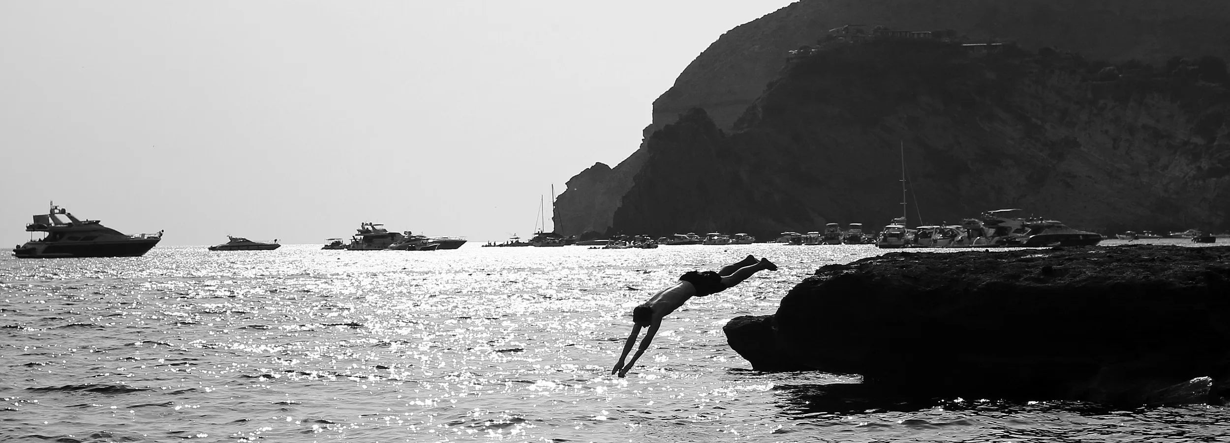 Man diving into the Mediterranean – highlighting Aboard Apparel’s timeless, durable clothing designed to stand the test of time and encourage mindful consumption.