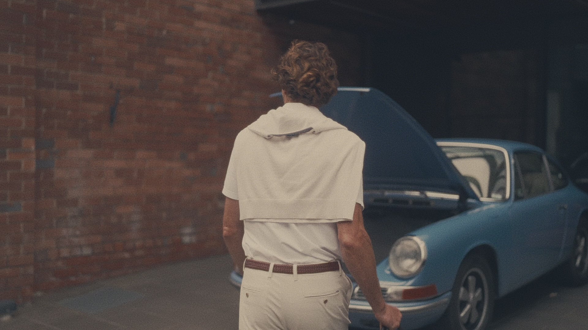 Man getting into Porsche wearing Aboard Apparel – combining timeless style with advanced technology for the modern traveler, designed for work, travel, and play. #hide_for_all